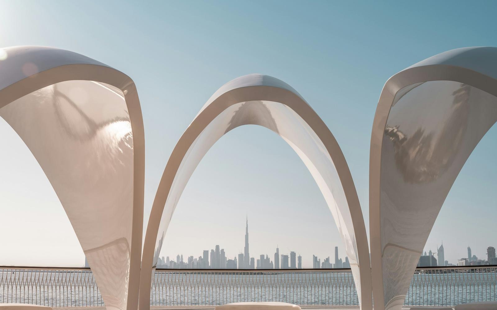 Sculptural white arches framing the Dubai skyline